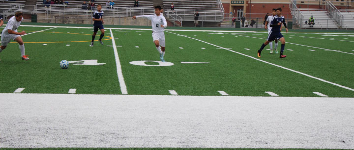 Sophomore Sebastian Contreras kicks the ball past defenders in their win vs. Plainfield South on October 15.