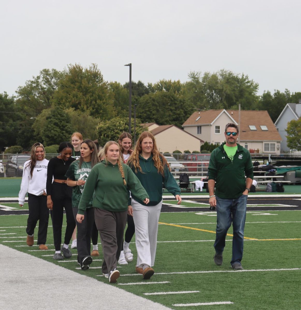 Girls Volleyball Team walking down the field.