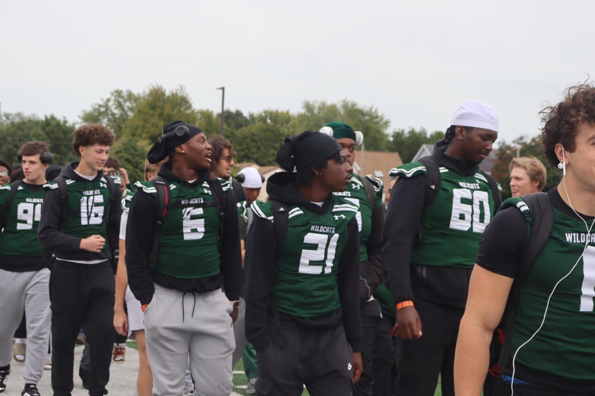 Members of the football team walking across field.