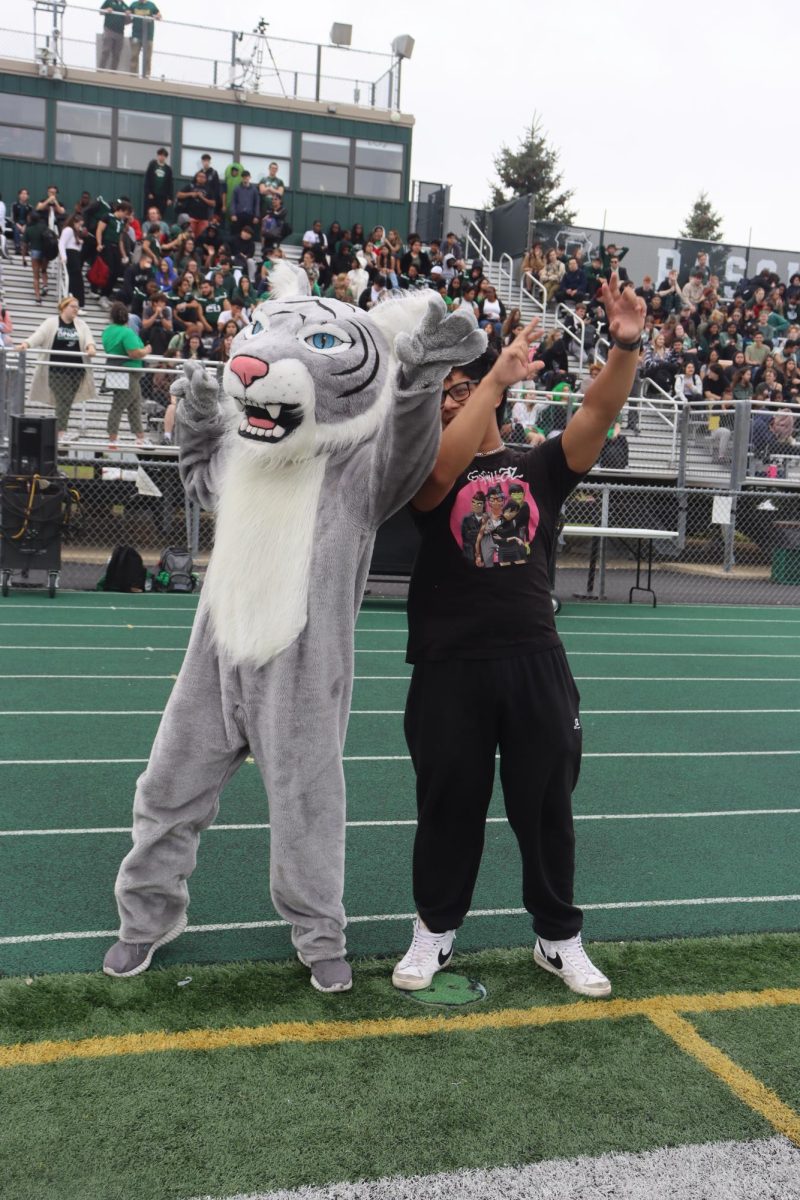 Senior Juan Garcia-Rivera and Willy the Wildcat having fun at the Pep Rally in front of the student section.