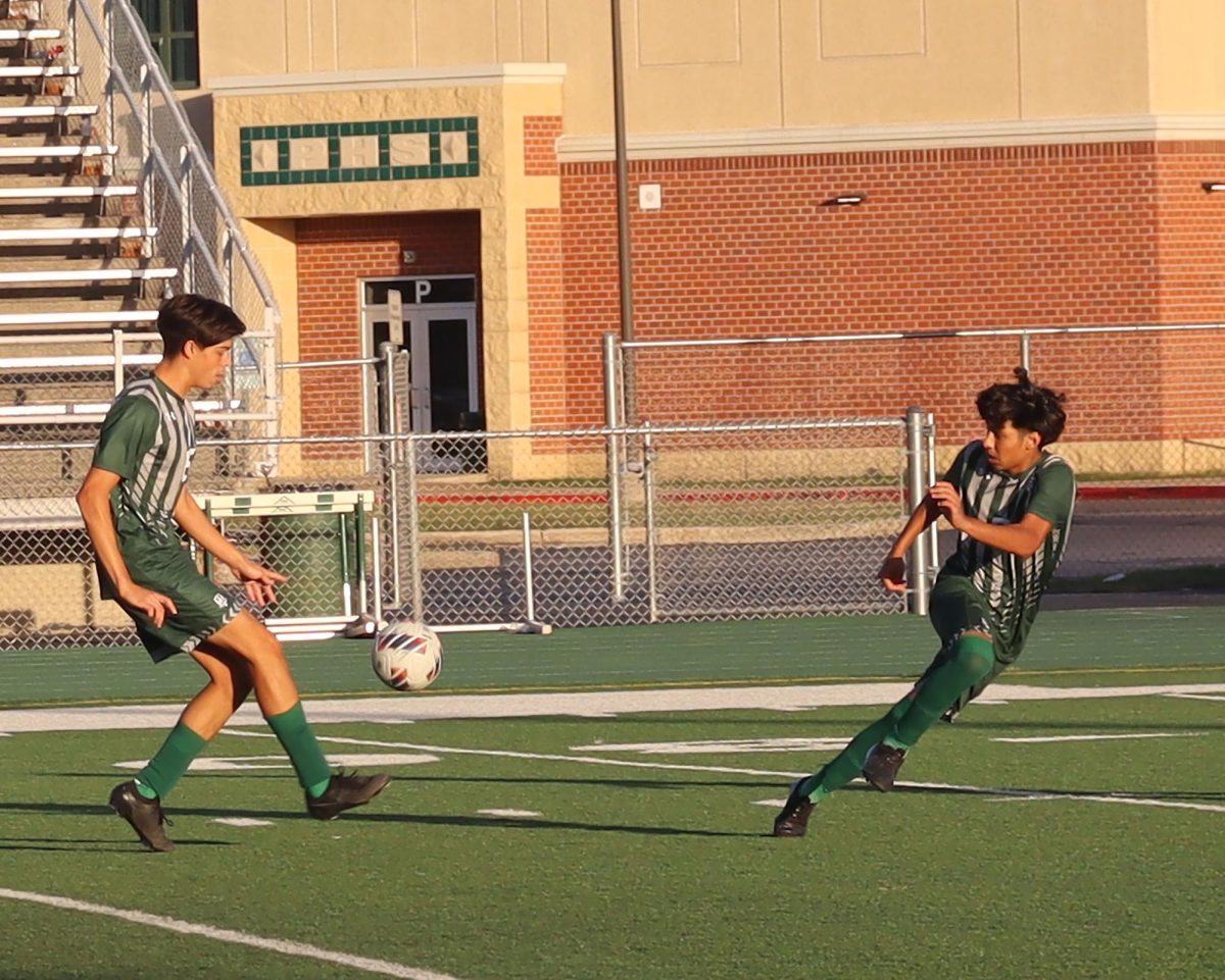 Sebastian Chavez, senior, passes the soccer ball to Leonardo Perez, sophomore, in their tie vs Romeoville 2-2 on Tuesday Oct. 8.