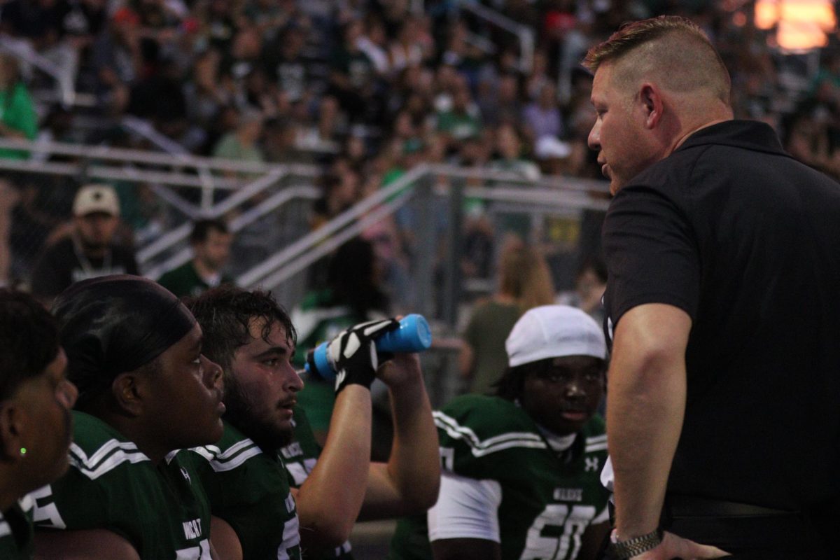 Head coach Robby Carriger pumps up his team during a time out at a home game versus Waukegan. The Wildcats fell 14-16 in a close battle.