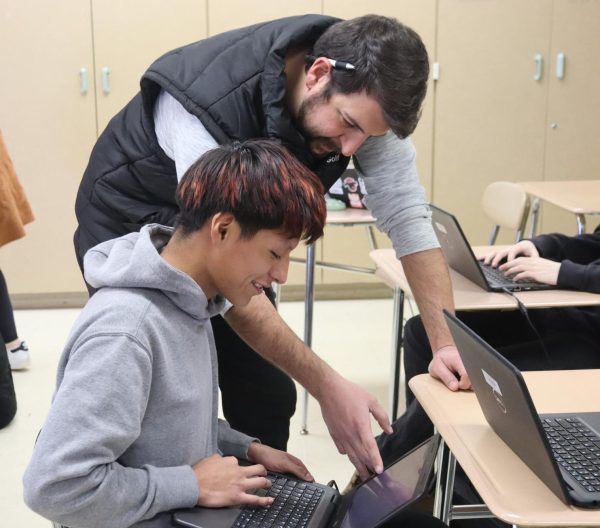 Brandon Sanders, English teacher, assists a student with Shakespeare sonnets.